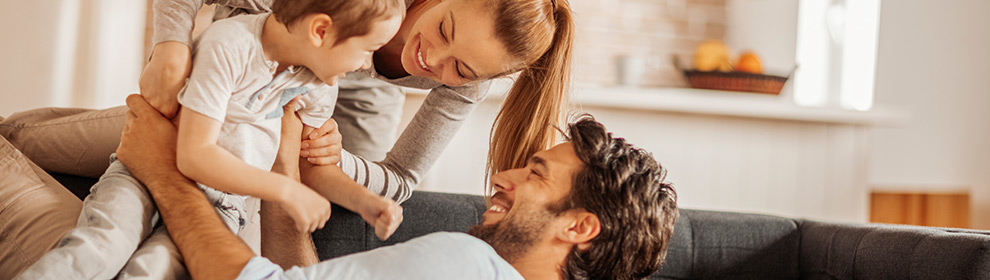 parents holding their son on the couch